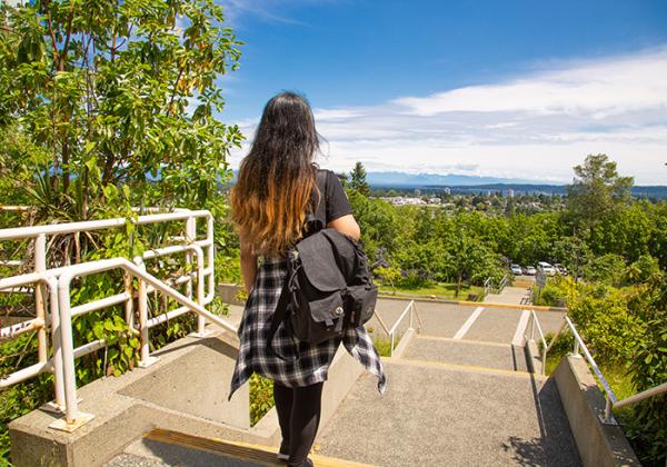 Young woman taking in the view from the top of a hill. 