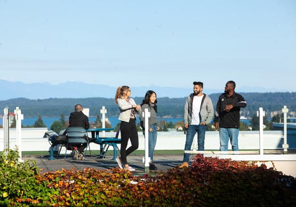Students on a rooftop overlooking a scenic view