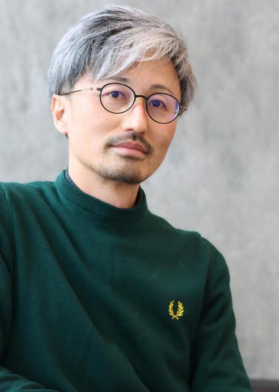 A man in glasses and a green sweater.