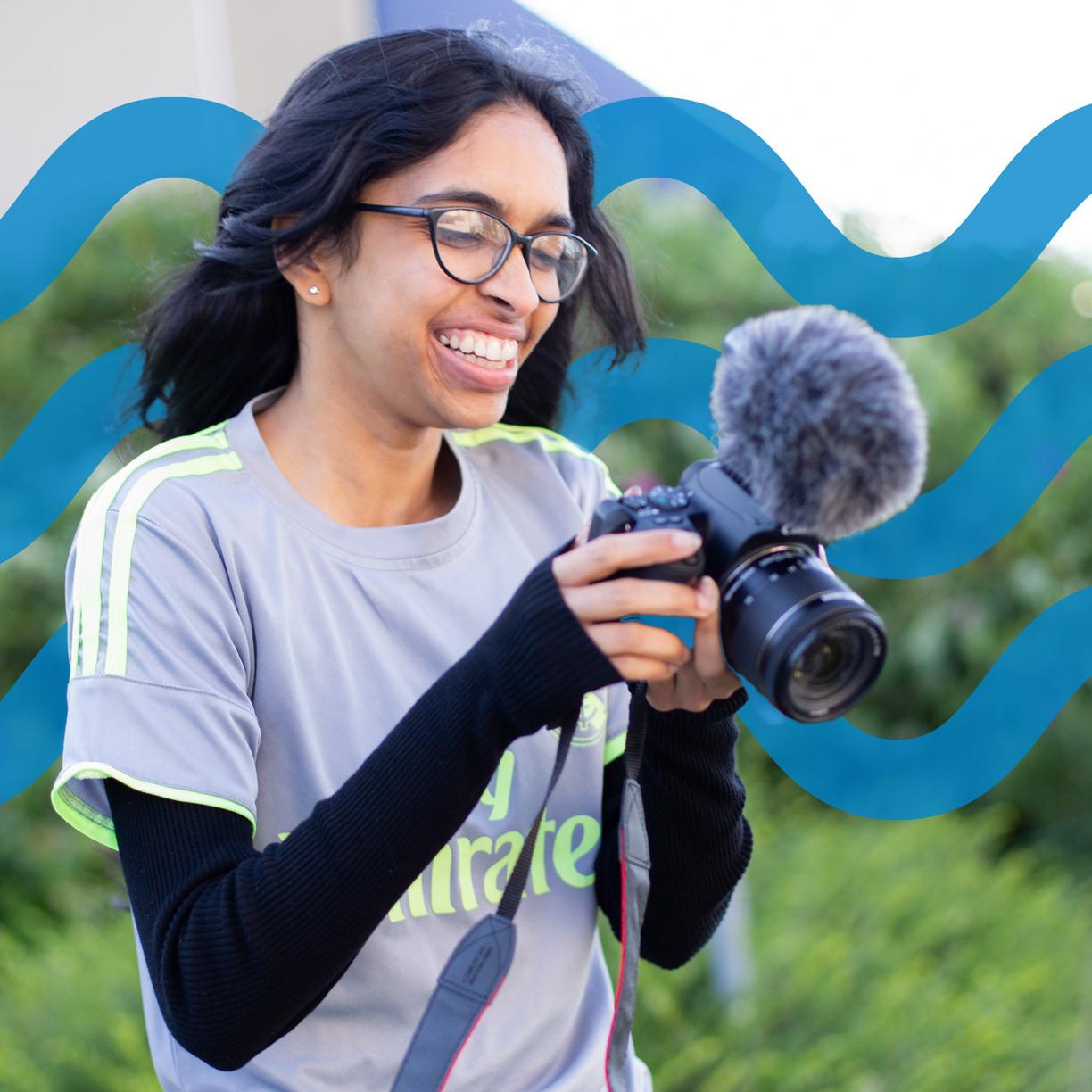 A woman with a microphone and camera.