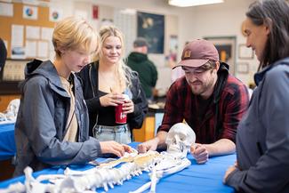 Teens and a VIU instructor looking at a skeleton