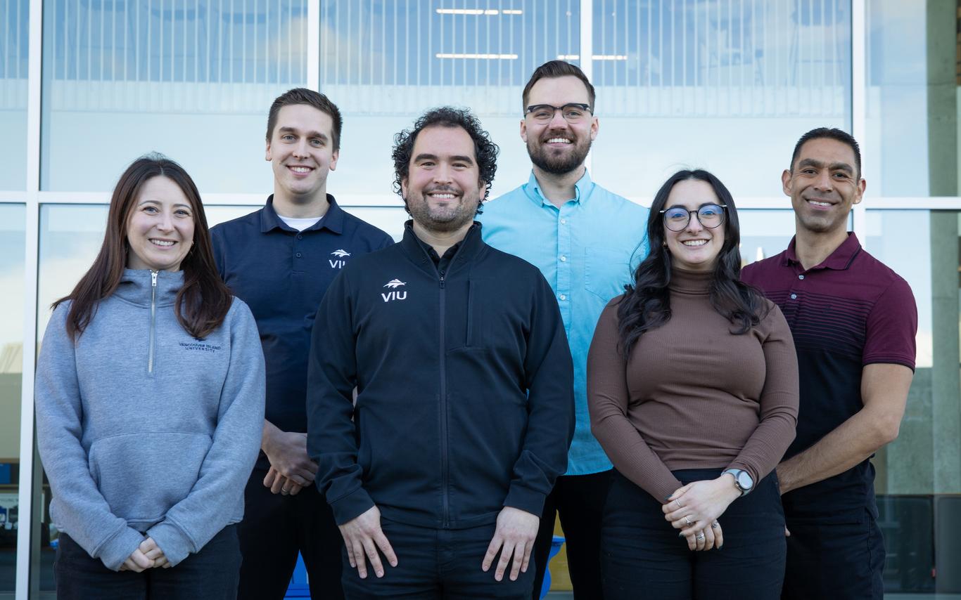 Smiling people standing together outside a building