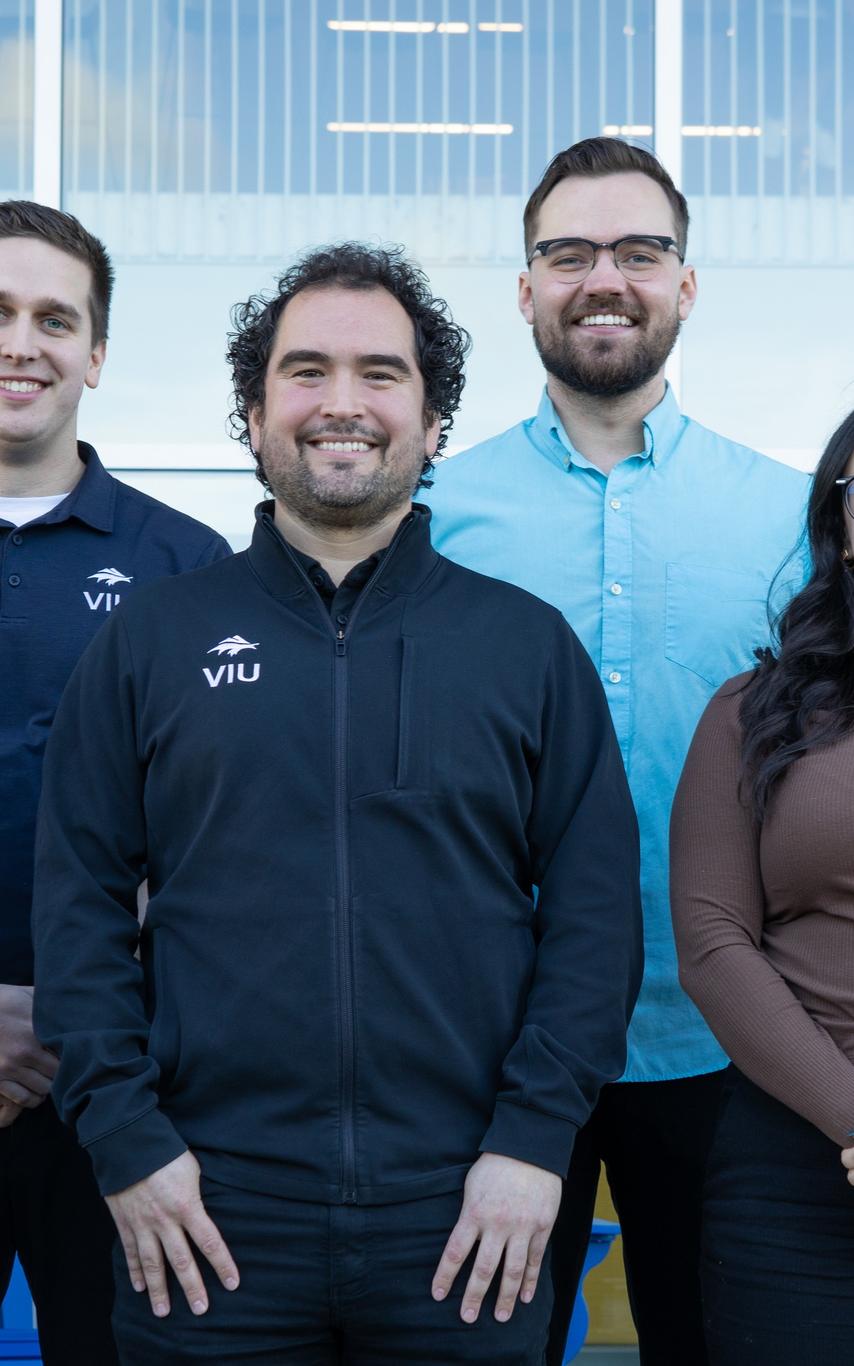 Smiling people standing together outside a building