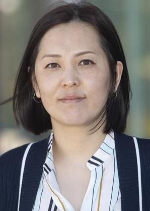 Young woman with dark hair wearing a blue blazer and shirt